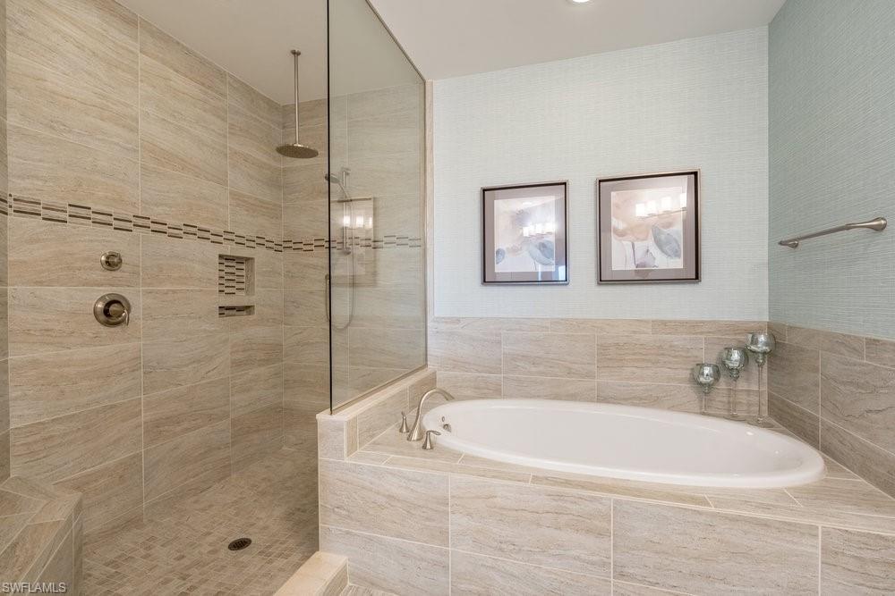 16444 Carrara Way, Unit 7301 Naples, FL 34110 - Photo 18 of 42 a white bath tub sitting next to a shower