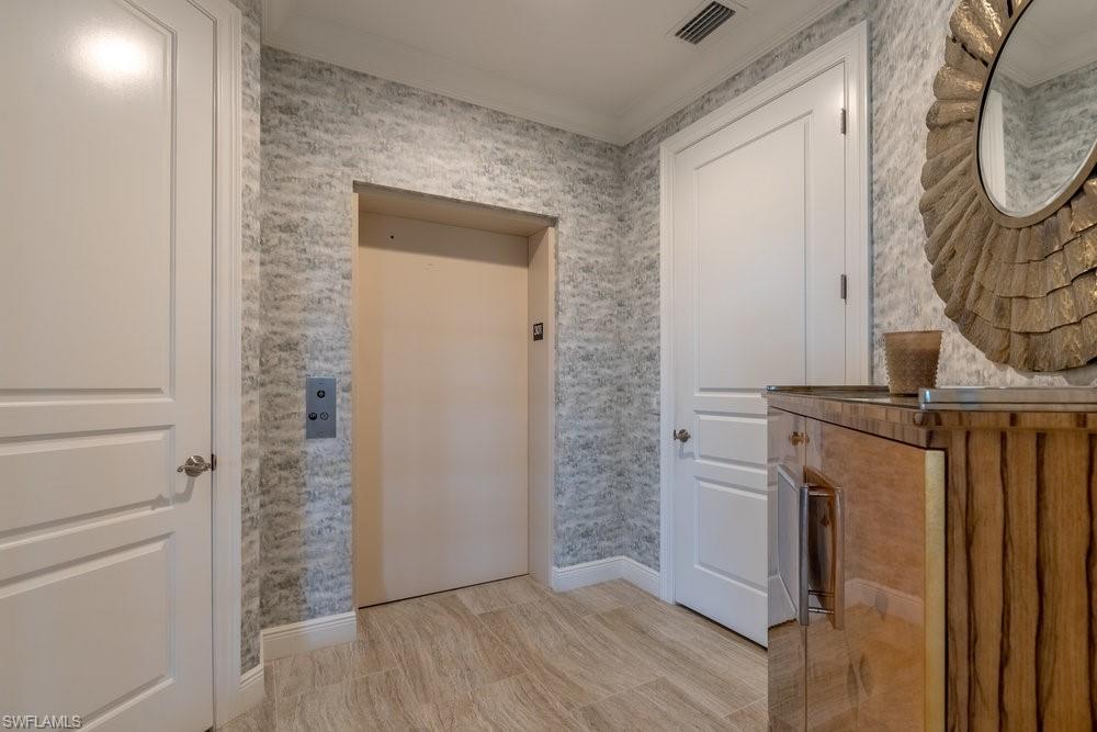 16444 Carrara Way, Unit 7301 Naples, FL 34110 - Photo 2 of 42 a view of a livingroom with wooden floor and a staircase