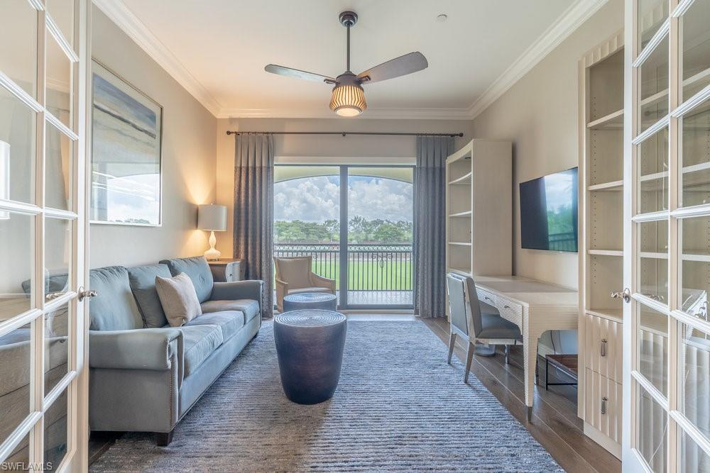 16444 Carrara Way, Unit 7301 Naples, FL 34110 - Photo 21 of 42 a living room with furniture a flat screen tv and a large window