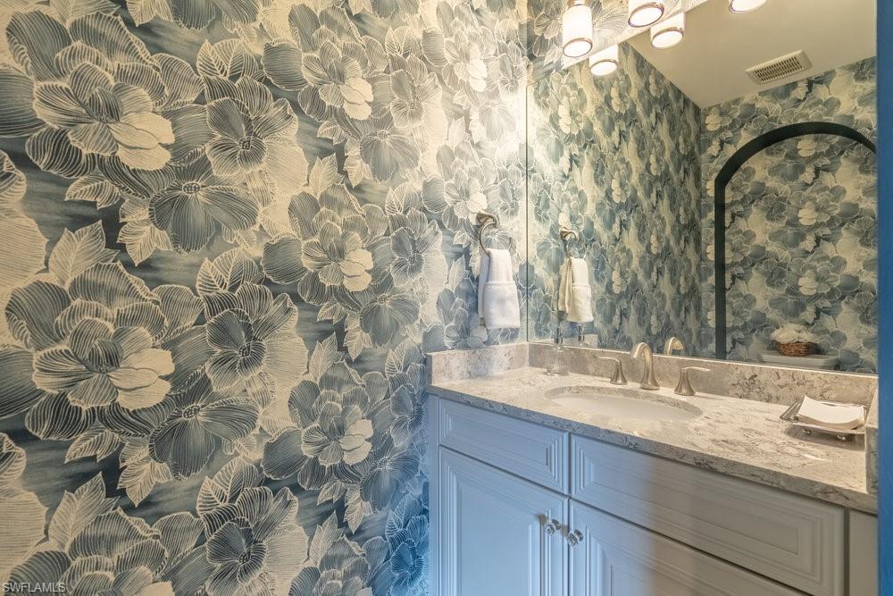 16444 Carrara Way, Unit 7301 Naples, FL 34110 - Photo 23 of 42 a bathroom with a granite countertop sink and a mirror