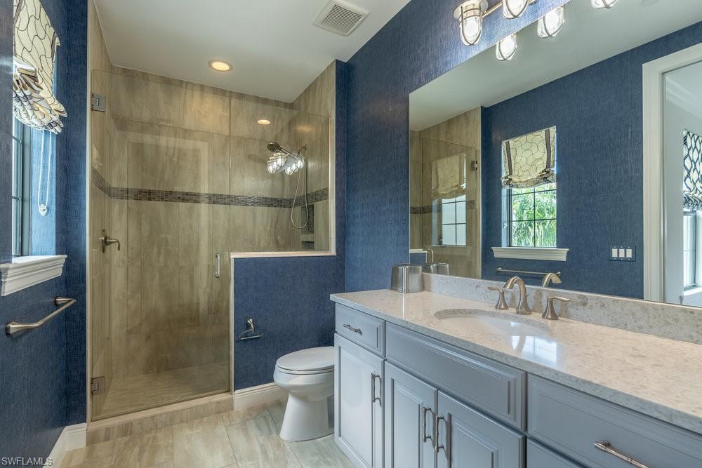 16444 Carrara Way, Unit 7301 Naples, FL 34110 - Photo 27 of 42 a bathroom with a sink a toilet a mirror and shower