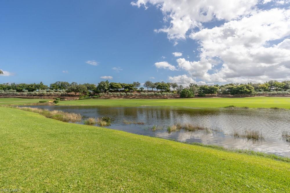16444 Carrara Way, Unit 7301 Naples, FL 34110 - Photo 30 of 42 a view of a lake with houses in the background