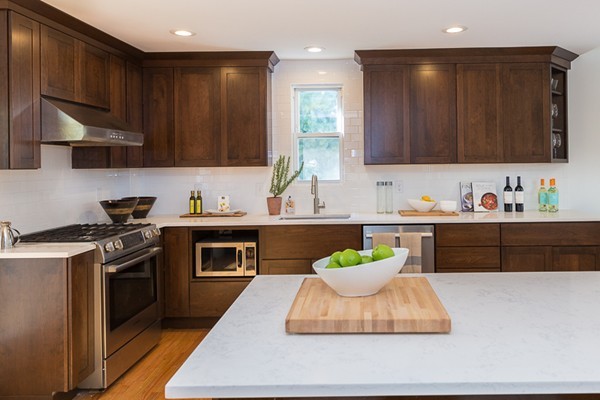 26 Vinal Avenue, Unit 1 Somerville, MA 02143 - Photo 9 of 17 a kitchen with kitchen island granite countertop a sink a stove and a wooden floors