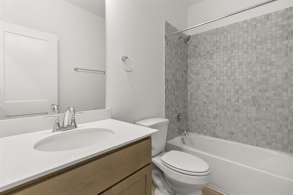 8239 Red Shiner Way Fulshear, TX 77441 - Photo 11 of 25 a bathroom with a sink a toilet and a bathtub