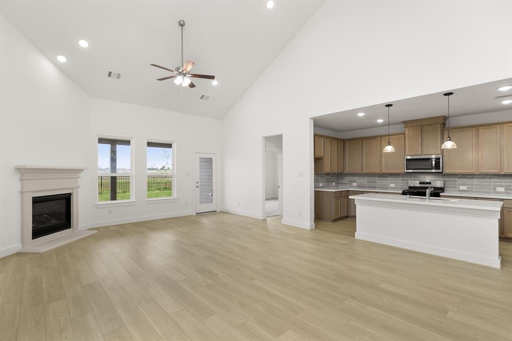 8239 Red Shiner Way Fulshear, TX 77441 - Photo 3 of 25 a view of kitchen with granite countertop a stove top oven a sink dishwasher a dining table and chairs with wooden floor
