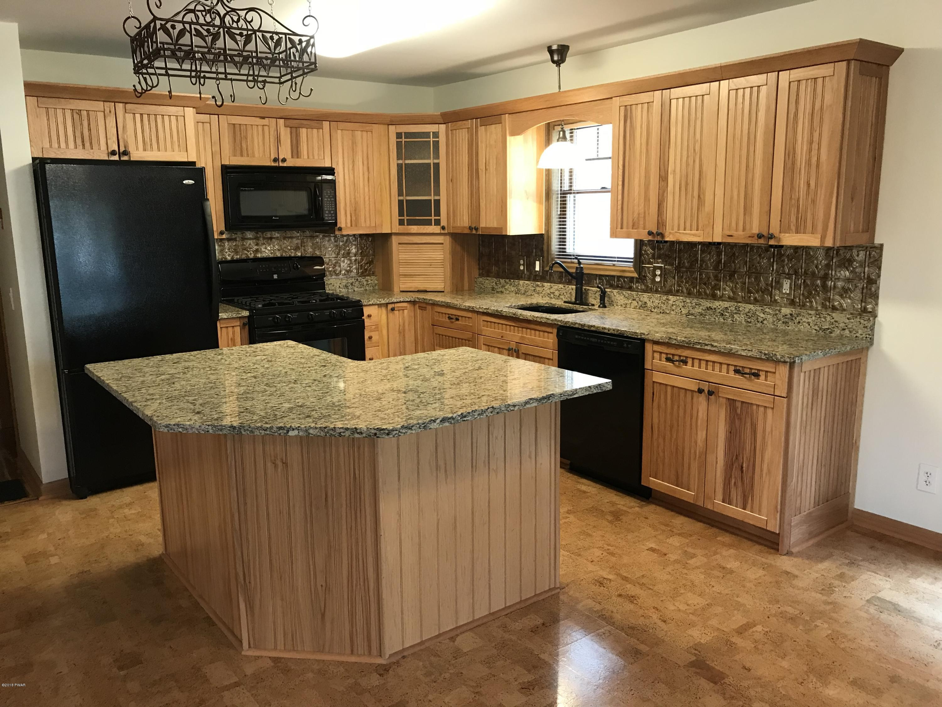 232 Maple Ridge Drive Hawley, PA 18428 - Photo 10 of 44 a kitchen with kitchen island granite countertop a stove top oven a sink dishwasher and a refrigerator