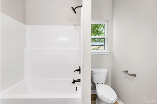a white toilet sitting next to a bath tub