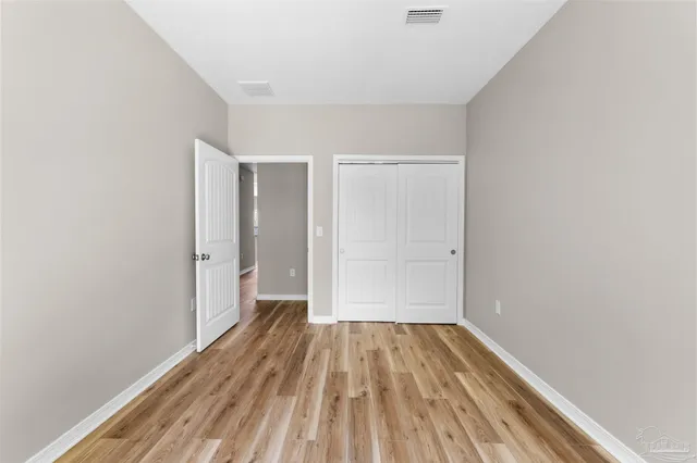 a view of a room with wooden floor and a window