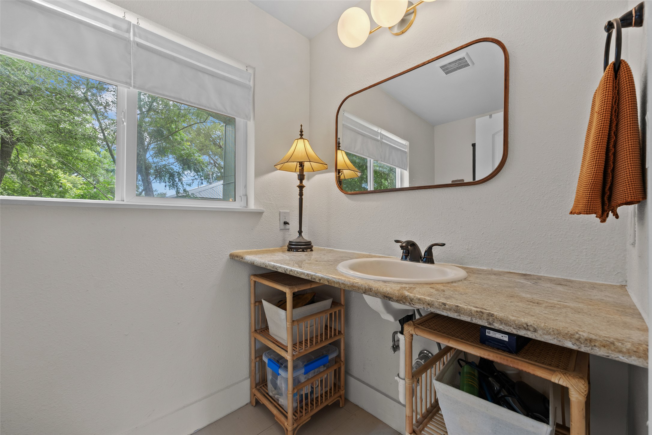 3302 Cherrywood Road Austin, TX 78722 - Photo 16 of 26 Functional vanity featuring a broad counter with integrated sink, offering ample space and natural light from the window.