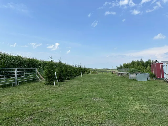 a view of a green field with wooden fence