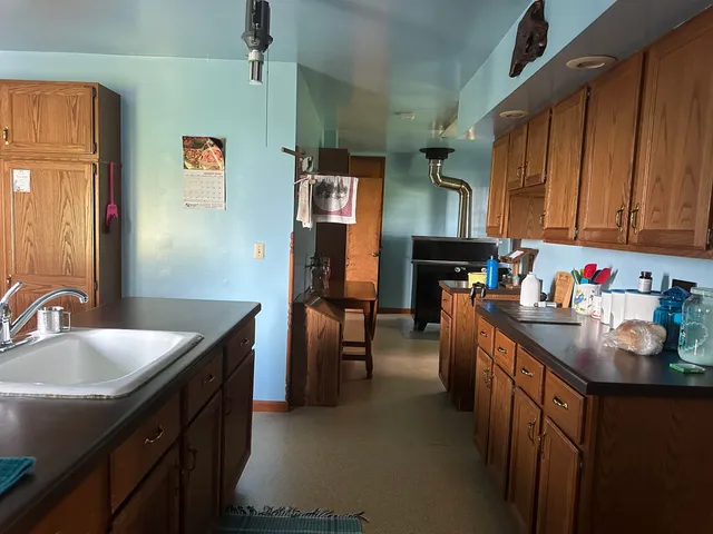 a kitchen that has a sink cabinets counter space and appliances