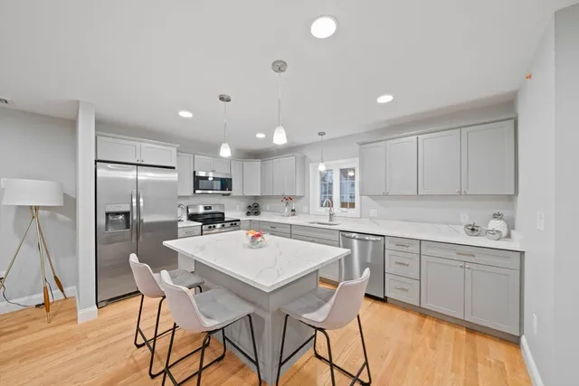 a kitchen with a table a refrigerator a cabinets and stools