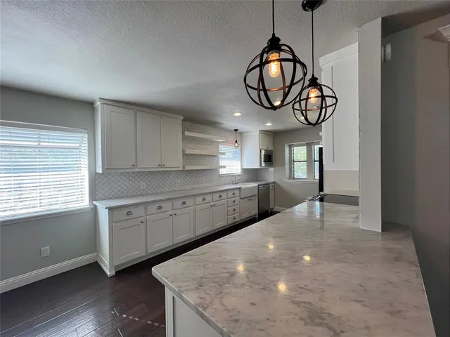 a kitchen with cabinets a window and stainless steel appliances