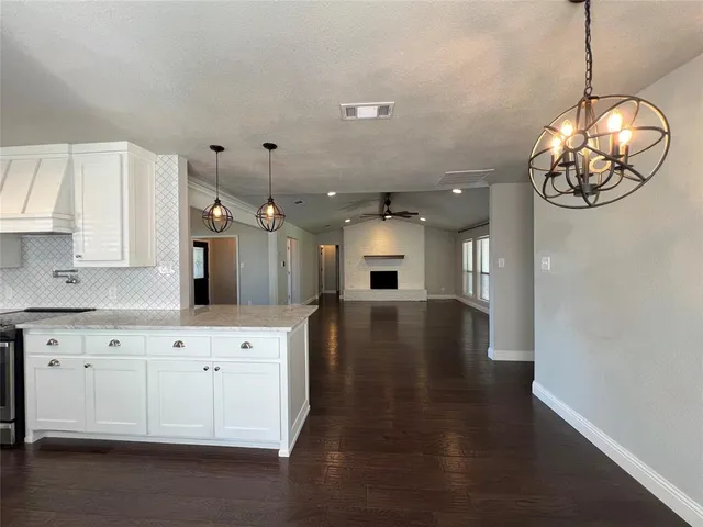a kitchen with a white cabinets and chandelier