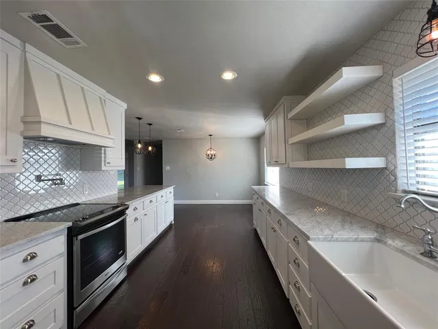 a large kitchen with stainless steel appliances granite countertop a lot of counter space