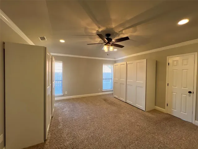 an empty room with a ceiling fan and a shower