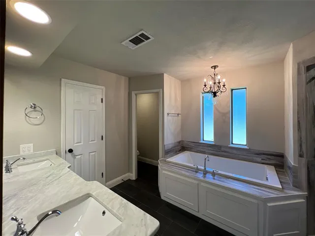 a bathroom with a tub sink and mirror