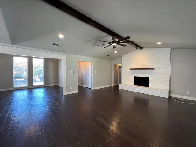 an empty room with wooden floor and fireplace