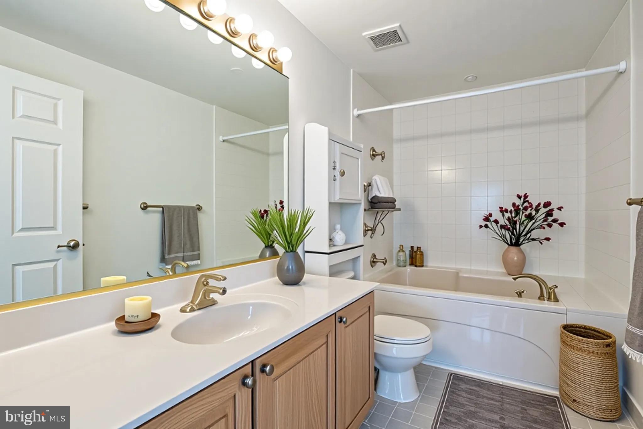 534 Runabout Loop, Unit 534 Solomons, MD 20688 - Photo 18 of 36 a bathroom with a granite countertop bathtub sink vanity mirror and toilet