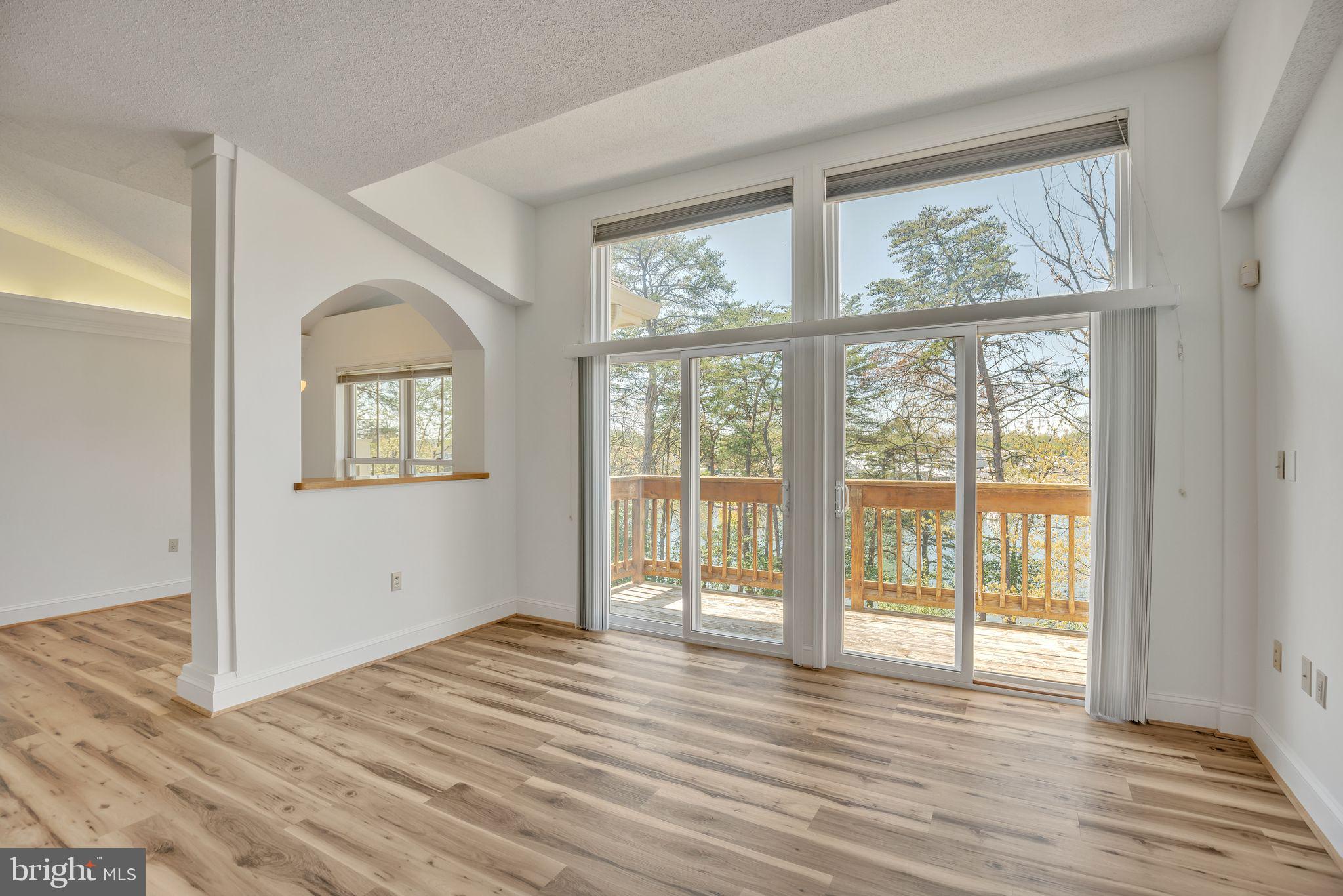 534 Runabout Loop, Unit 534 Solomons, MD 20688 - Photo 22 of 36 a view of an empty room with wooden floor and a window
