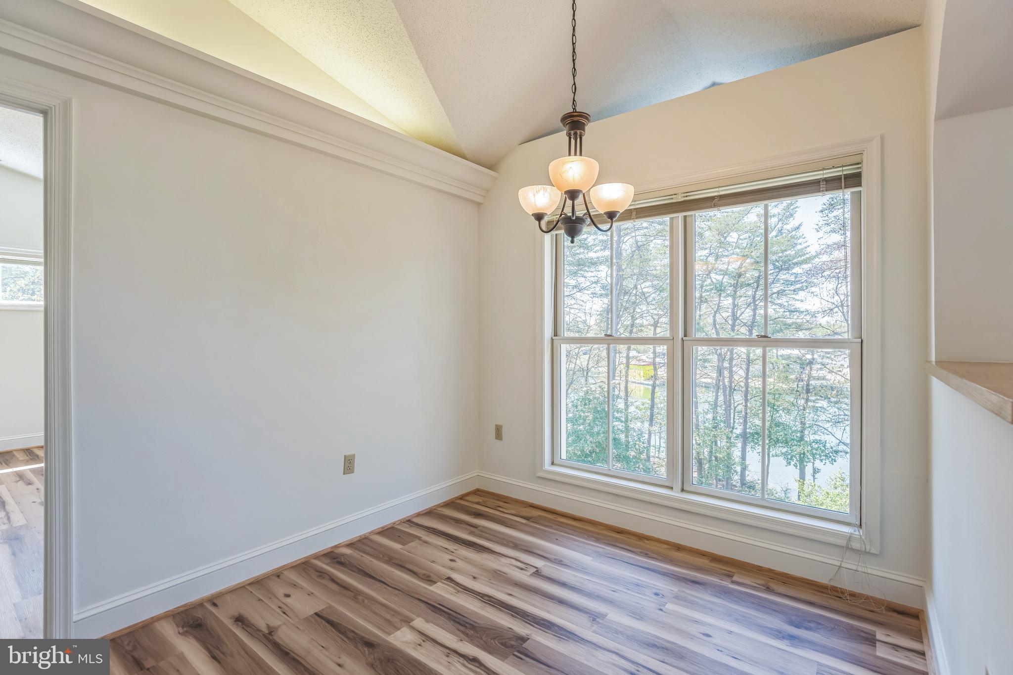 534 Runabout Loop, Unit 534 Solomons, MD 20688 - Photo 25 of 36 a view of an empty room with wooden floor chandeliers and a window
