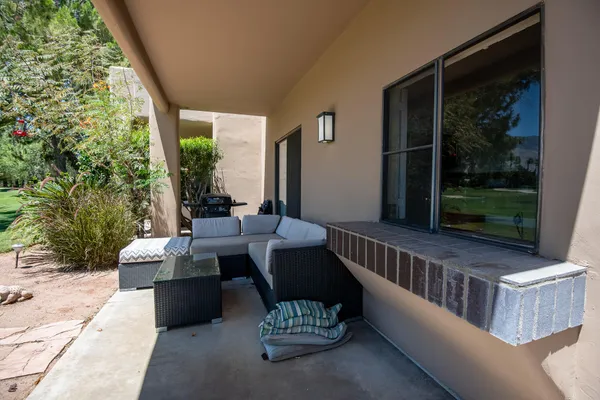 a view of a patio with couches table and chairs and potted plants