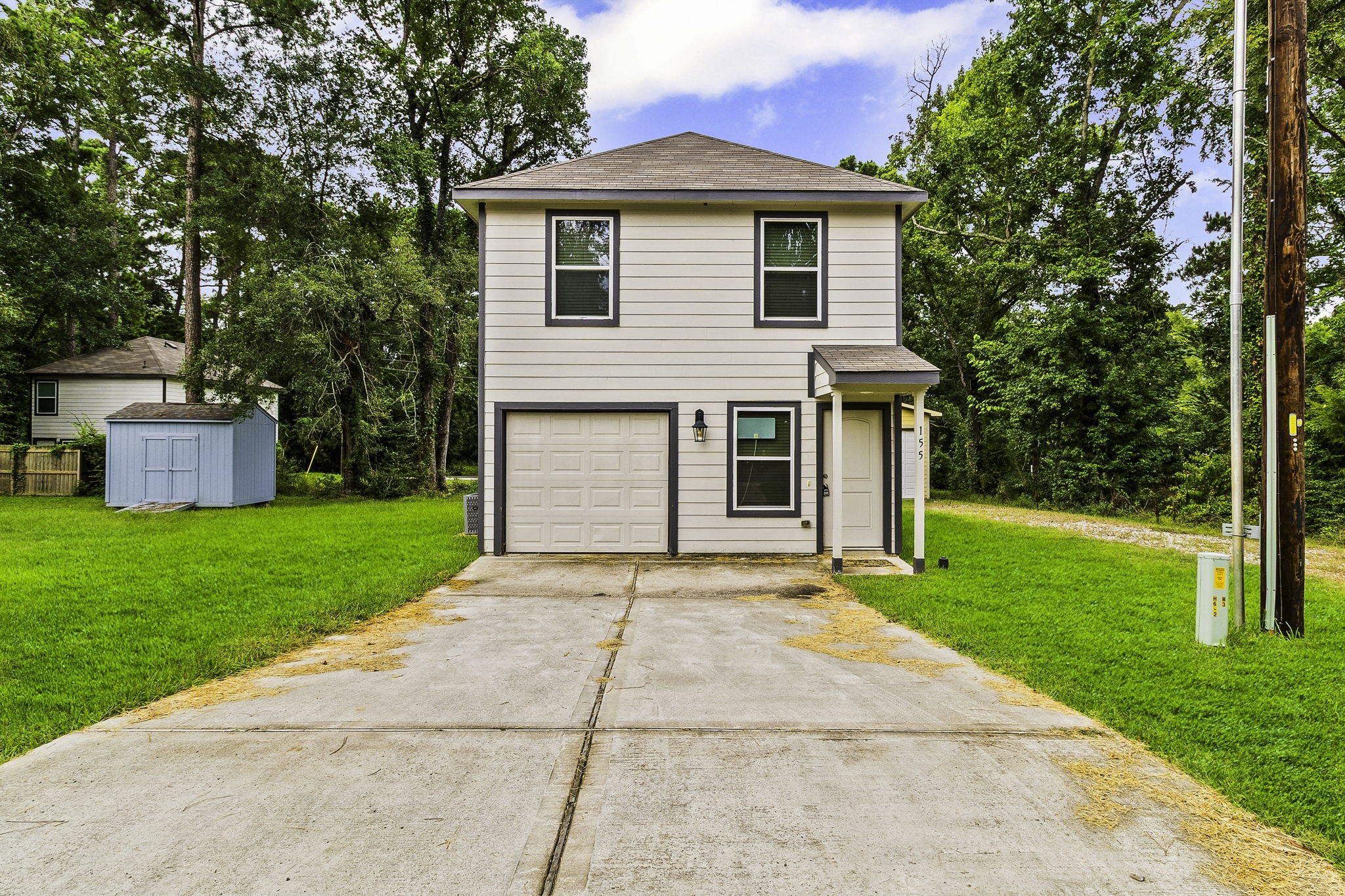 155 Cherry Tree Livingston, TX 77351 - Photo 1 of 30 a front view of a house with a yard and a garage