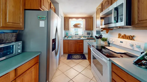 a kitchen with a refrigerator and a stove top oven