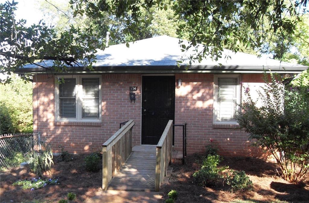a front view of a house with a tree