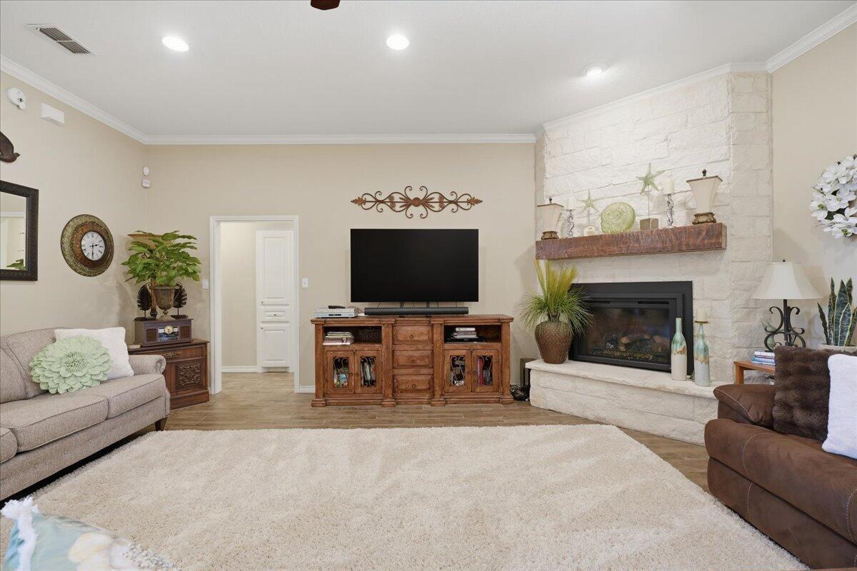 4612 100th Street Lubbock, TX 79424 - Photo 9 of 55 a living room with furniture a flat screen tv and a fireplace
