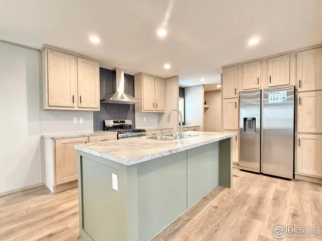 a kitchen with kitchen island granite countertop a sink appliances cabinets and a counter top space