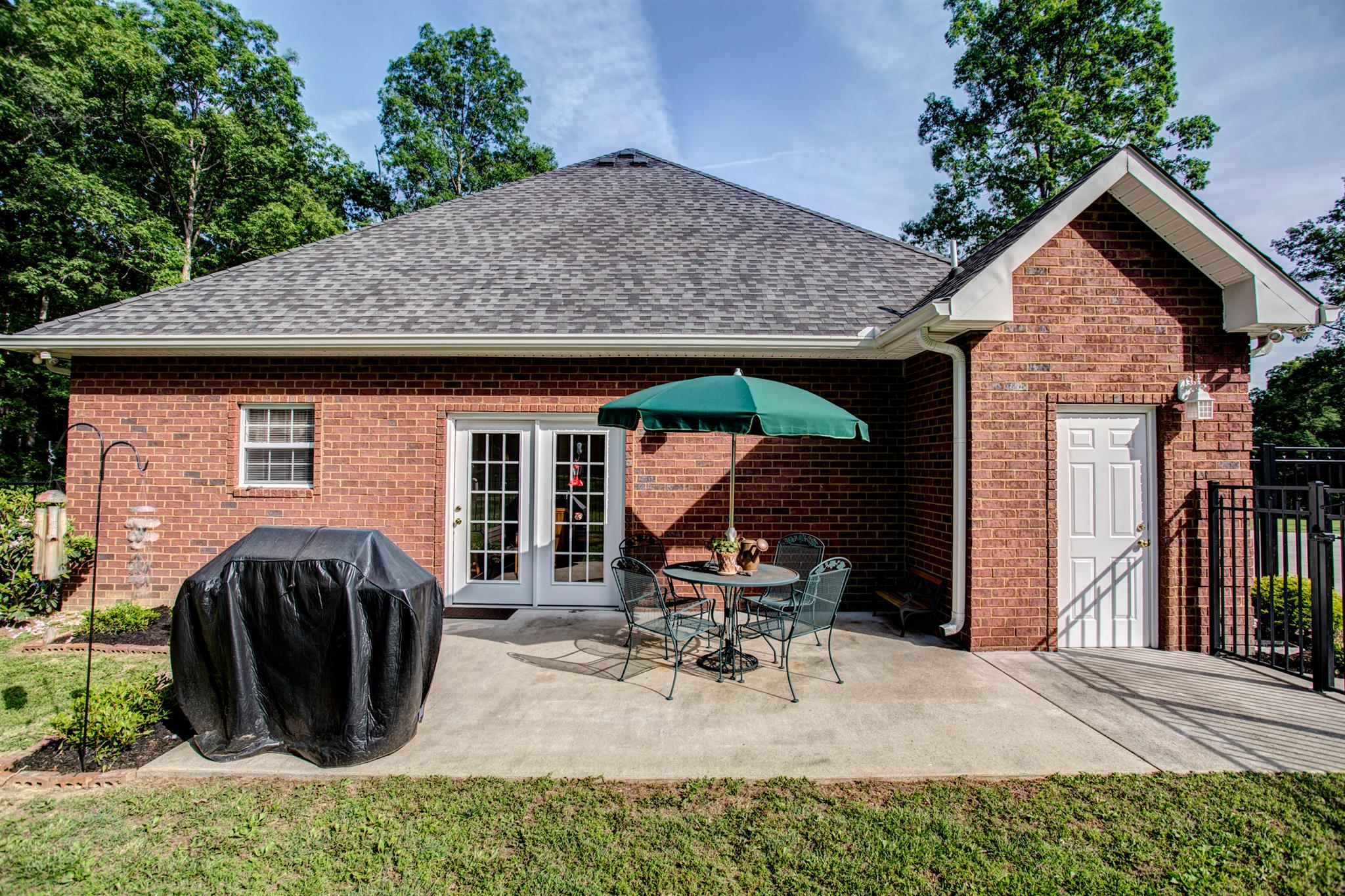 3350 Maxie Jones Road Springfield, TN 37172 - Photo 16 of 30 a view of a patio with table and chairs under an umbrella with a barbeque
