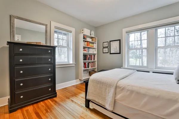a bedroom with a bed and a flat tv screen on dresser