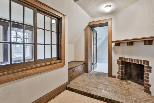 a view of empty room with wooden floor and fireplace