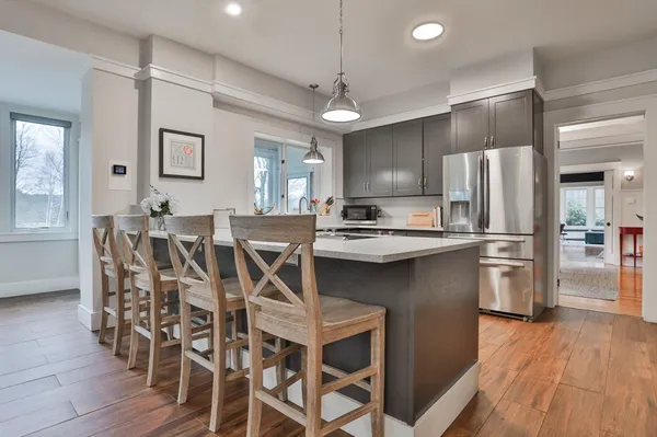 a kitchen with stainless steel appliances a refrigerator a sink dishwasher a stove and a oven with wooden floor