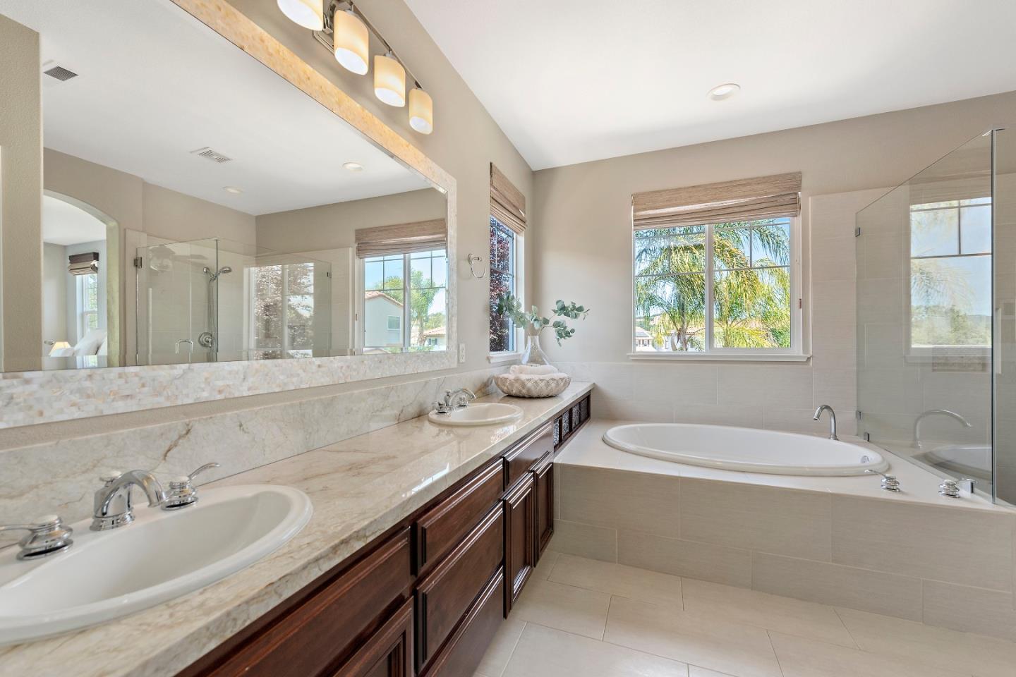 7581 Edinburgh Way Gilroy, CA 95020 - Photo 17 of 38 a bathroom with a granite countertop tub a sink and a window