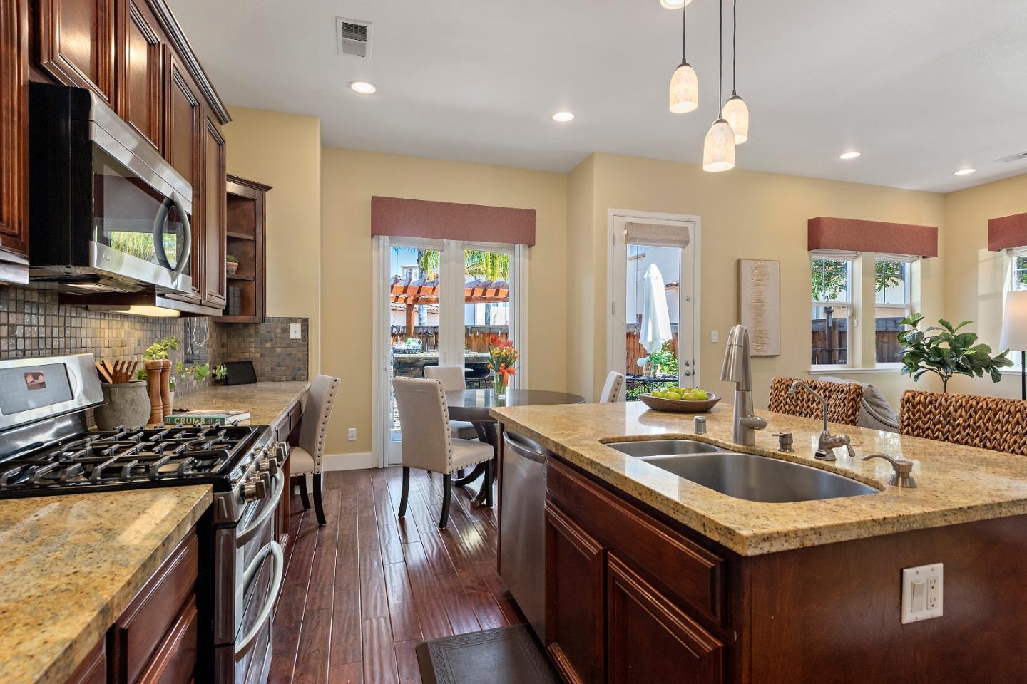 7581 Edinburgh Way Gilroy, CA 95020 - Photo 9 of 38 a kitchen with stainless steel appliances granite countertop a sink stove and cabinets