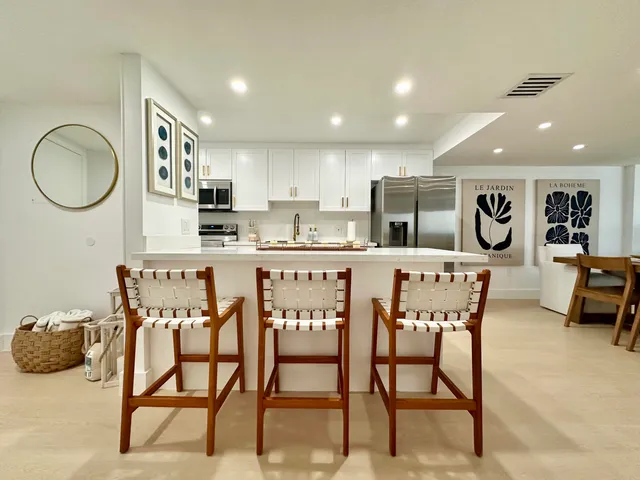 a bedroom with a bed potted plants on the table and a large mirror next to window