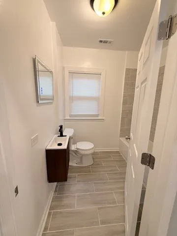 a bathroom with a toilet sink and mirror