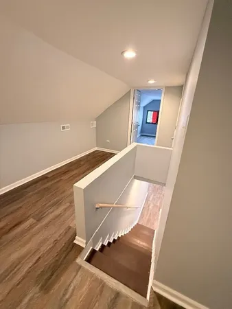 a view of a hallway with wooden floor and staircase