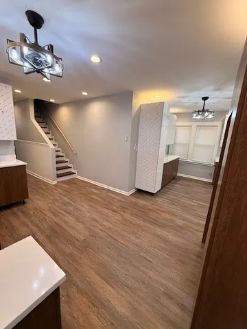 a view of a hallway with wooden floor and staircase
