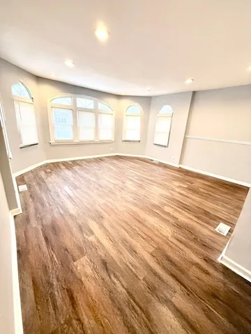 a view of a livingroom with wooden floor and window