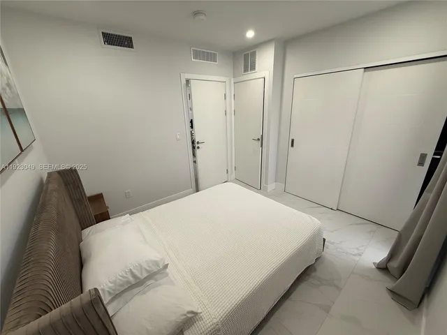 a bedroom with a bed and a refrigerator