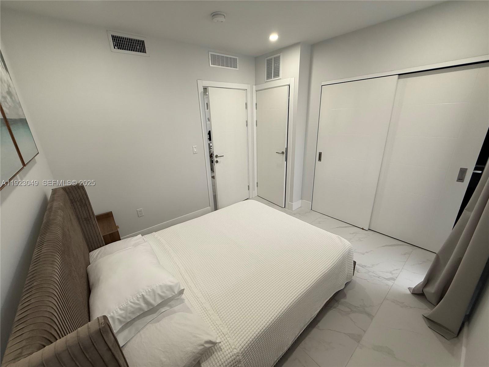 944 Jefferson Avenue, Unit 15 Miami Beach, FL 33139 - Photo 11 of 15 a bedroom with a bed and a refrigerator