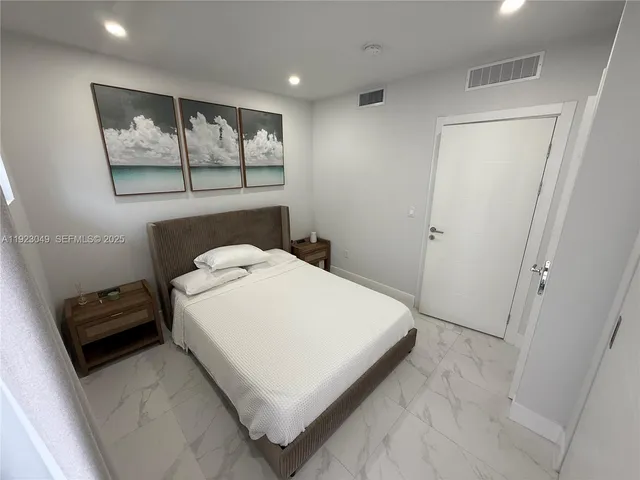 a white bed sitting in a bathroom next to a window