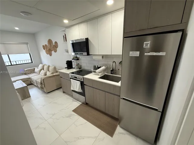 a kitchen with a refrigerator and a sink