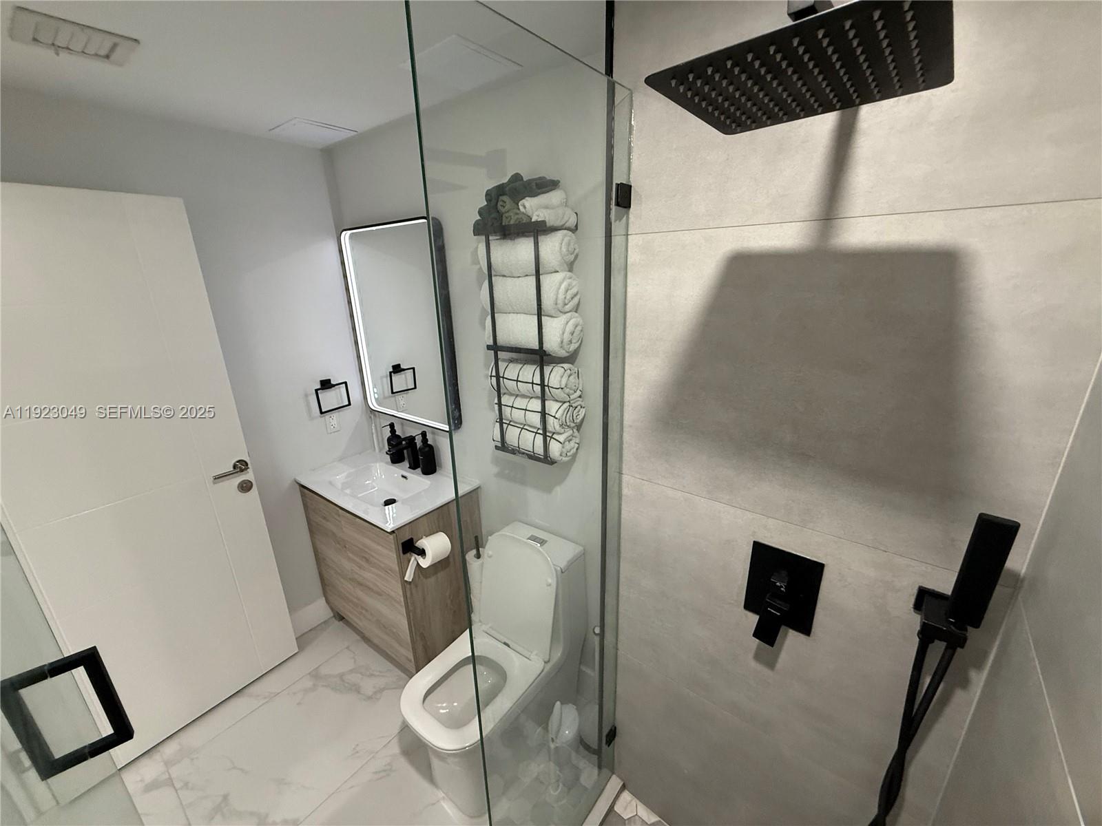 944 Jefferson Avenue, Unit 15 Miami Beach, FL 33139 - Photo 8 of 15 a bathroom with a mirror and a shower