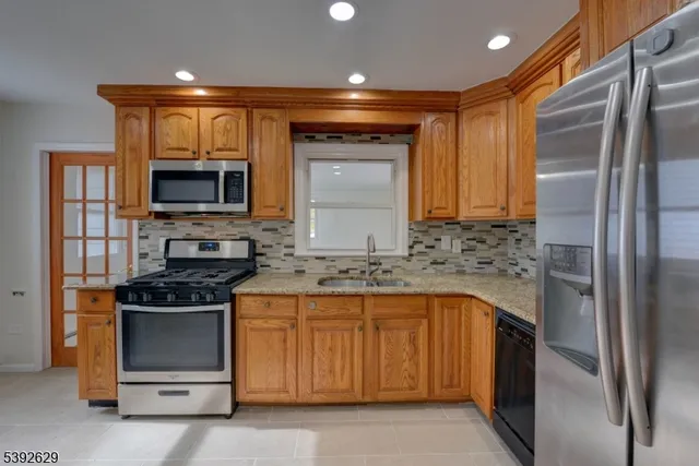 a kitchen with stainless steel appliances granite countertop a stove microwave and refrigerator