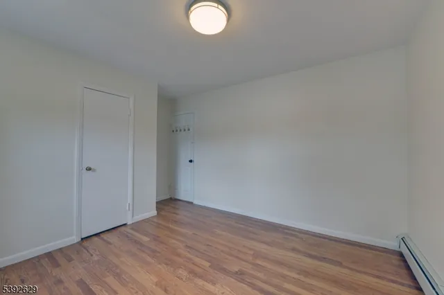 a view of a room with wooden floor and windows