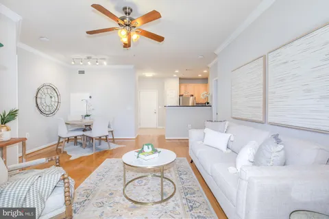 a living room with furniture kitchen view and a window